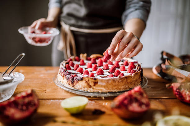 Adding Raspberries To Tasteful Blackberry Pie Woman Putting Raspberries To American Blackberry Pie, While It Is In  Mold Home Baking Business stock pictures, royalty-free photos & images