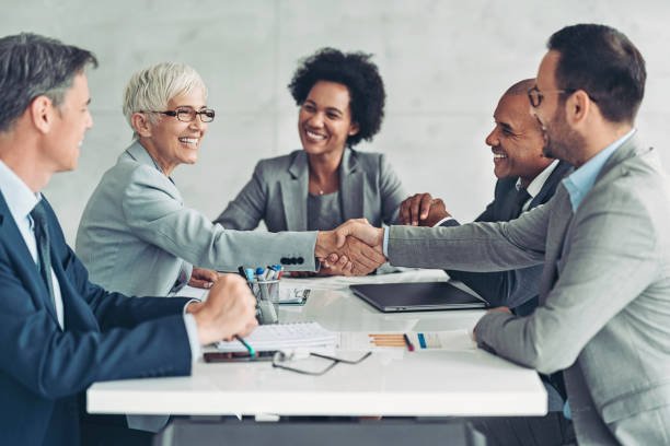 Businesswoman and businessman shaking hands across the table Business persons shaking hands on a meeting Approval stock pictures, royalty-free photos & images