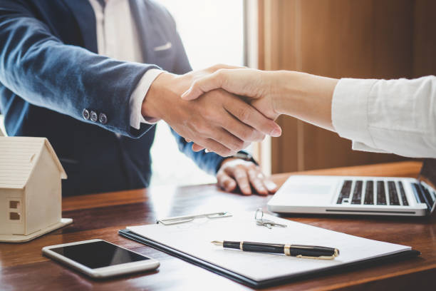 Real estate agent and customers shaking hands together celebrating finished contract after about home insurance and investment loan, handshake and successful deal Real estate agent and customers shaking hands together celebrating finished contract after about home insurance and investment loan, handshake and successful deal. Business Ownership stock pictures, royalty-free photos & images