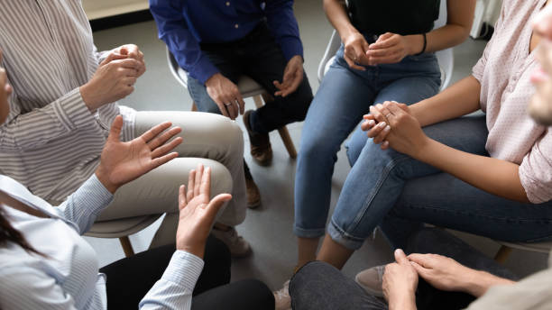 People participating in corporate teambuilding or rehabilitation session activity Top close up view in circle sit people, corporate teambuilding activity solve issues talk think together or alcohol rehab addiction treatment, twelve-step program, physical, mental, spiritual concept organizations that help patients stock pictures, royalty-free photos & images