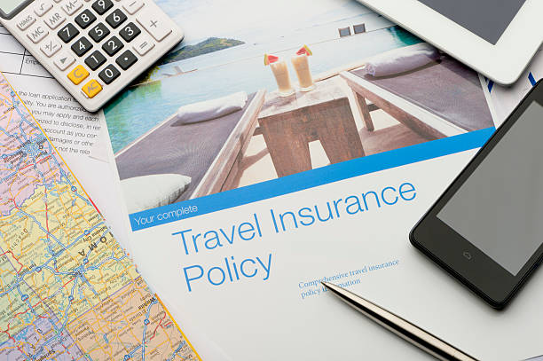 Travel insurance brochures and magazines. Travel insurance policy document with paperwork and technology. There is an image of a tourist resort with cocktails and a swimming pool which adds to the peace of mind concept. There is also a mobile phone, map, digital tablet and calculator. Image featured on the brochure can be found in my portfolio 20943516 travel insurance  stock pictures, royalty-free photos & images