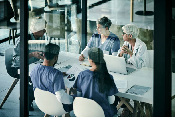He always leads by example Shot of a group of medical professionals having a meeting together inside a boardroom at a hospital working spaces  stock pictures, royalty-free photos & images