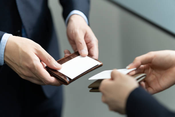 A close-up of a Japanese businessman exchanging business cards A close-up of a Japanese businessman exchanging business cards Business Card stock pictures, royalty-free photos & images