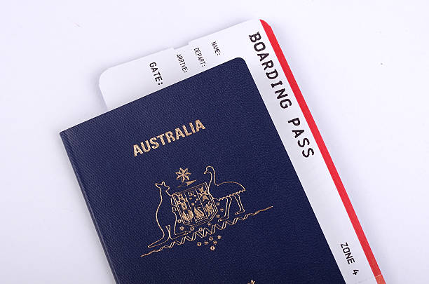 Australian Passport with International boarding pass One new Australian passport with an international boarding pass inserted inside the document. Travelling to Australia  stock pictures, royalty-free photos & images