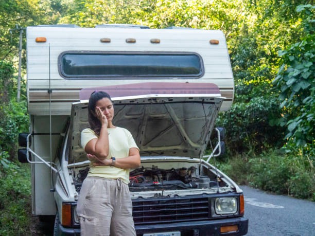 Campervan breakdown, desperate woman She stands in front of the RV with an anxious face looking at the camera. Mobile Home Insurance stock pictures, royalty-free photos & images