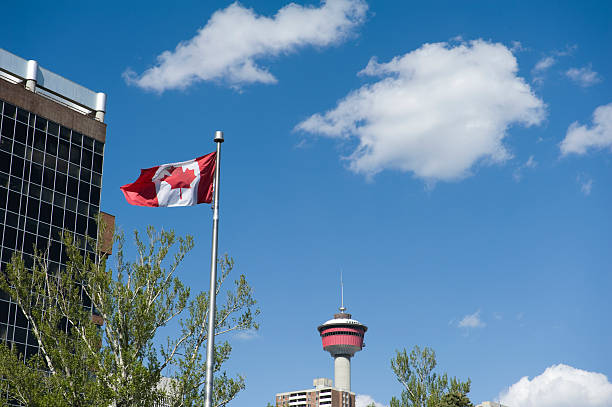 Canadian flag with Calgary tower seen from central memorial park Canadian flag with Calgary tower seen from central memorial park waetern union calgary stock pictures, royalty-free photos & images