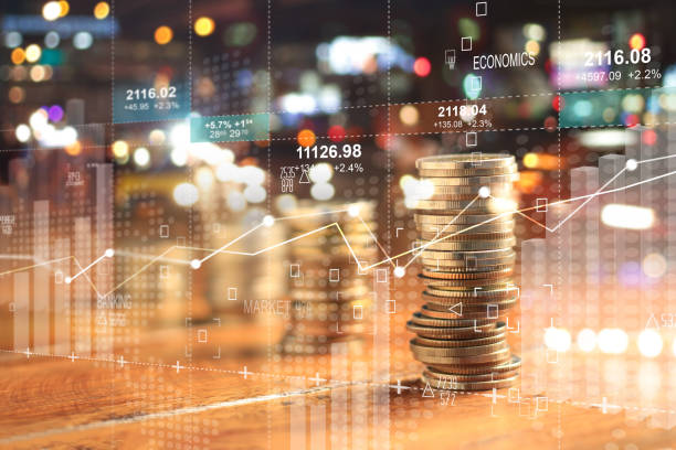 Double explosure with businesss charts of graph and rows of coins for finance at night city background. Double explosure with businesss charts of graph and rows of coins for finance at night city background. Gold Banking stock pictures, royalty-free photos & images