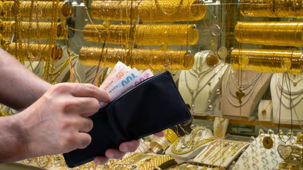 male hand taking money out of wallet male hand taking money out of wallet in jewelery shop Gold Banking  stock pictures, royalty-free photos & images