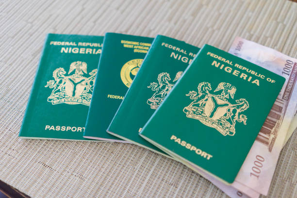 Nigerian Passport with Nigerian Naira For Travel and Vacation Nigerian Passport for travel and identification to ensure easy travels Nigerian Passport stock pictures, royalty-free photos & images